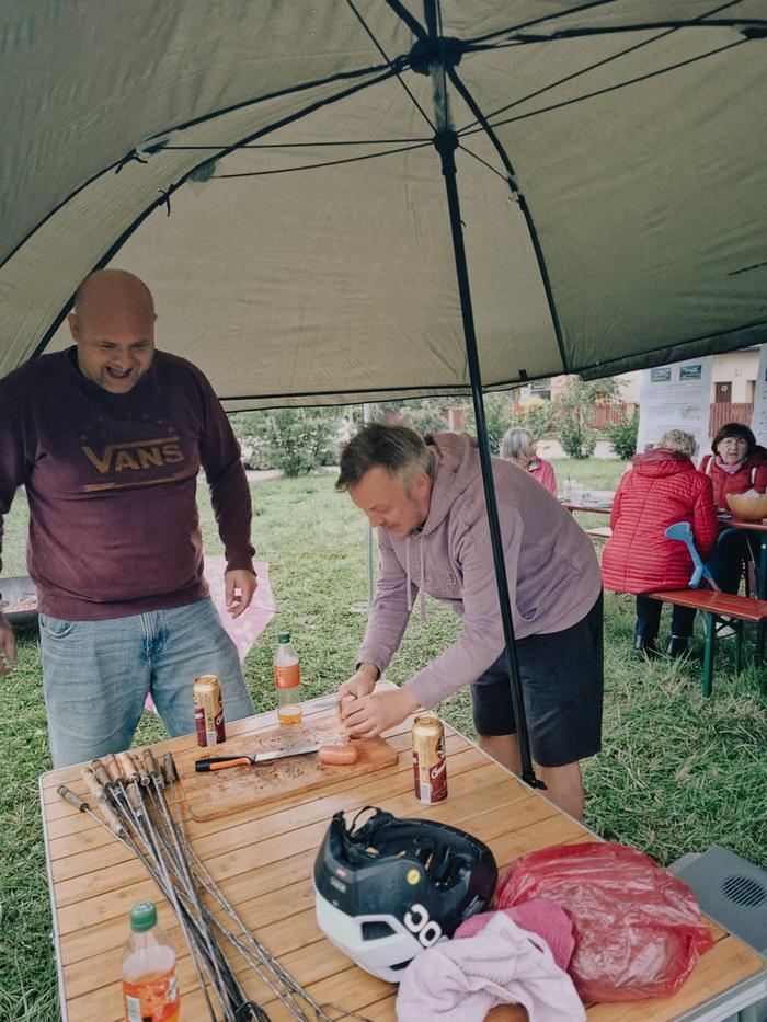 Dva muži chystají pod přístřeškem občerstvení