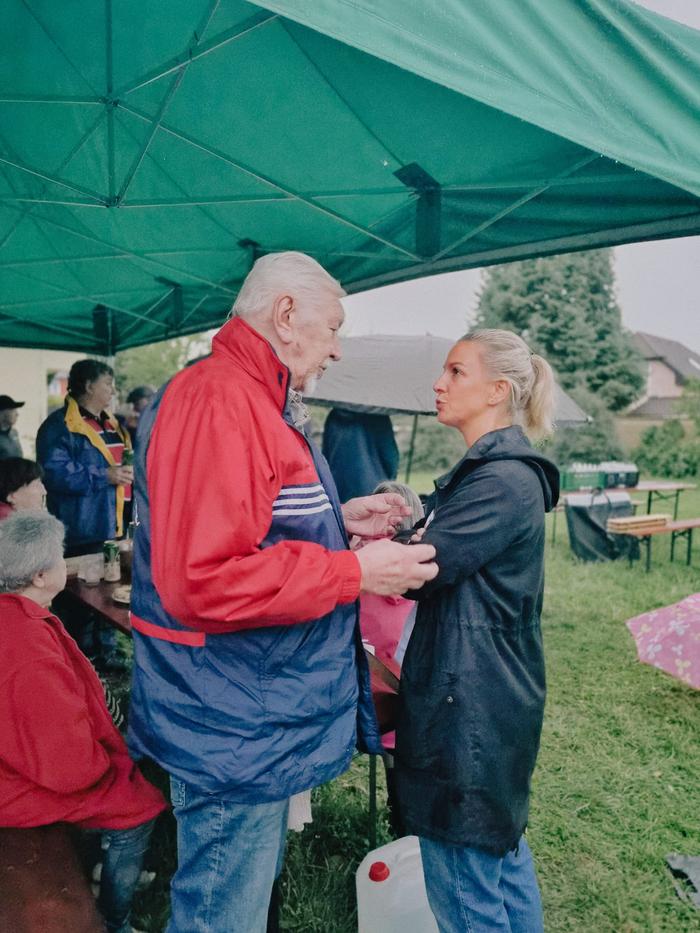 Muž a žena spolu hovoří pod přístřeškem