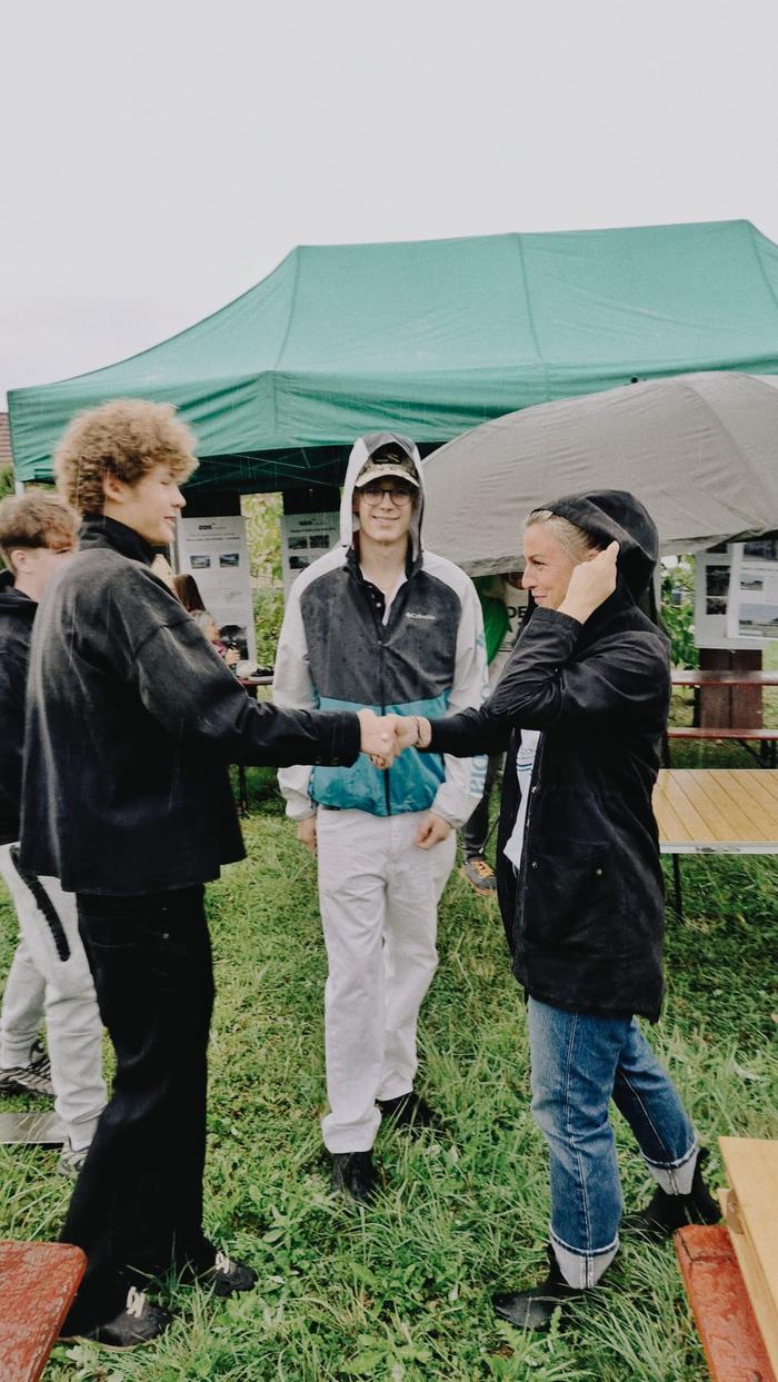 Tři mladí lidé si podávají ruce
