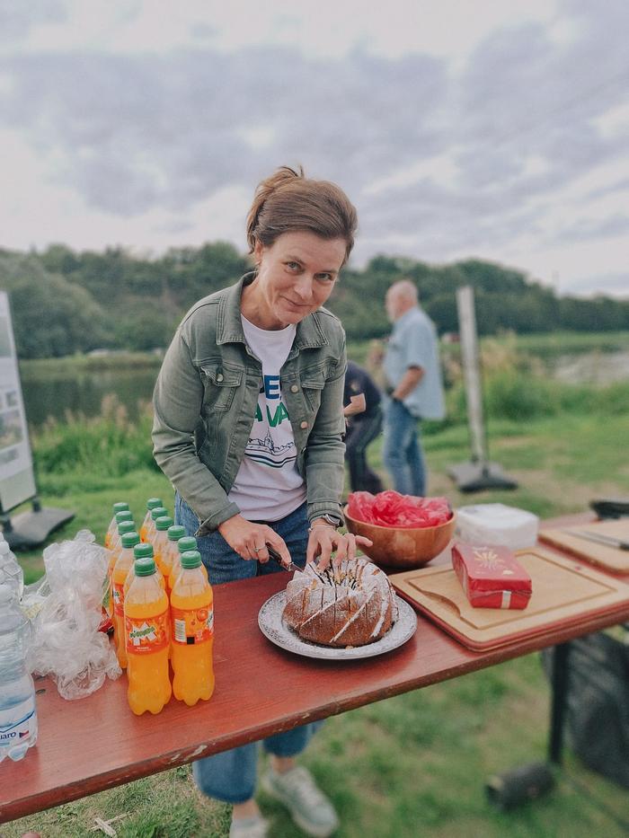 Žena krájí u stolu bábovku, vedle stojí mísa s ovocem